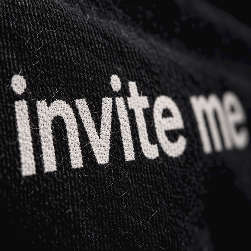 Macro close-up of the white screen print on black cotton jersey, showing the fabric weave
